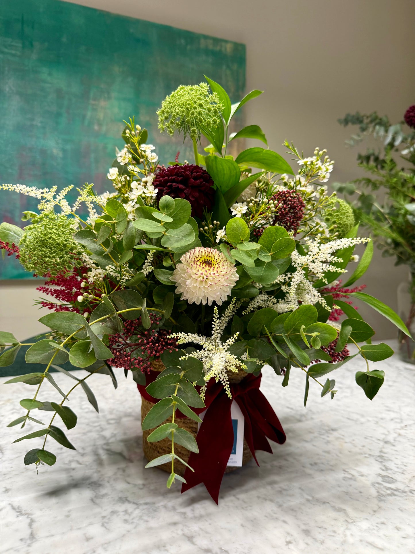 Arreglo floral en cesta en tonos burdeos y blancos