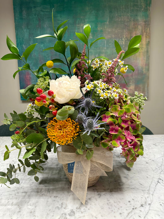 Arreglo Floral Tonos Naranjas y Azules en Cesta