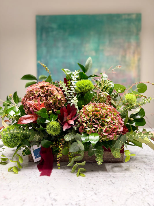 Arreglo floral en caja con colores otoñales y hortensias