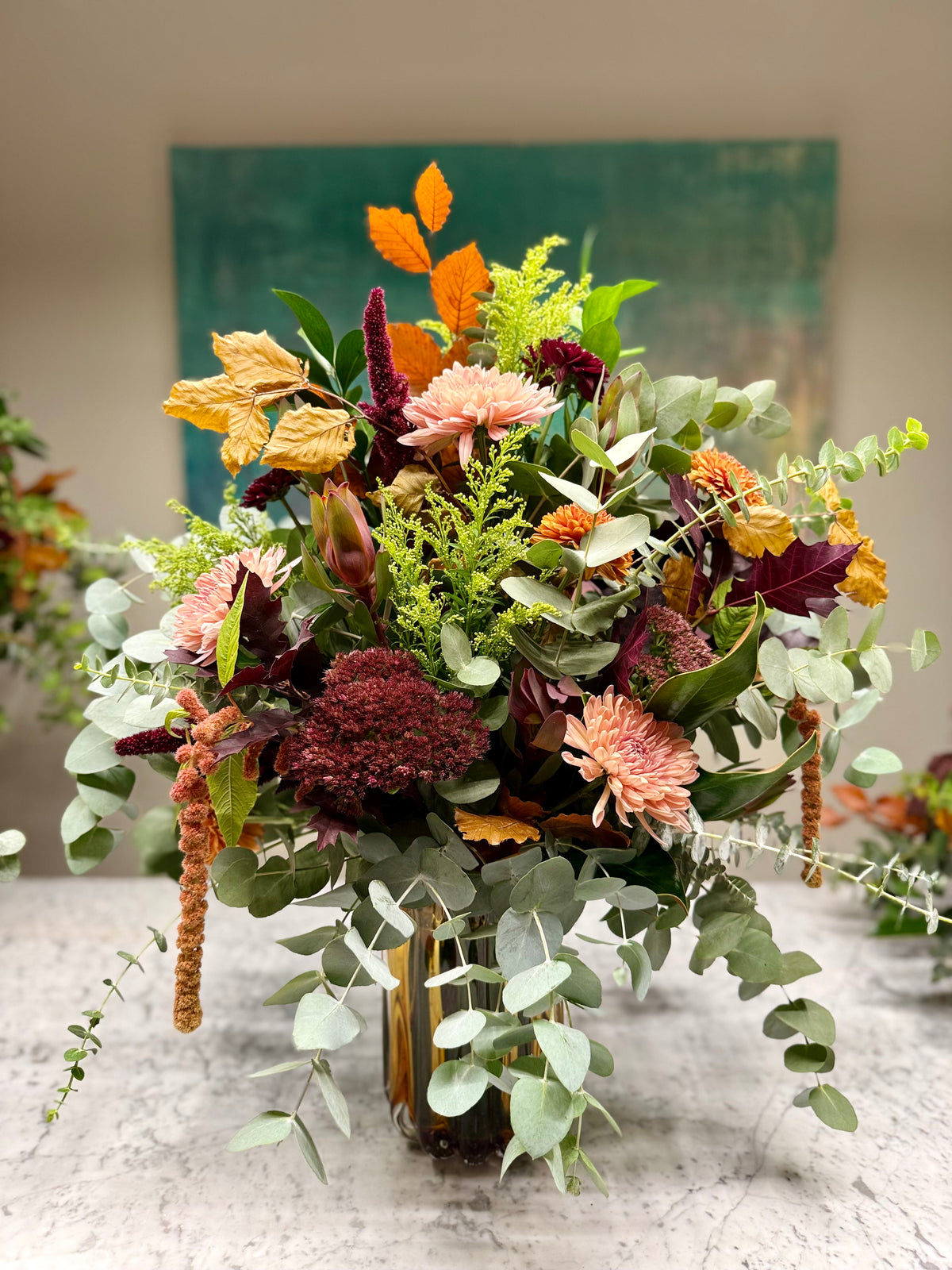 Arreglo floral en jarrón naranja en tonos de otoño