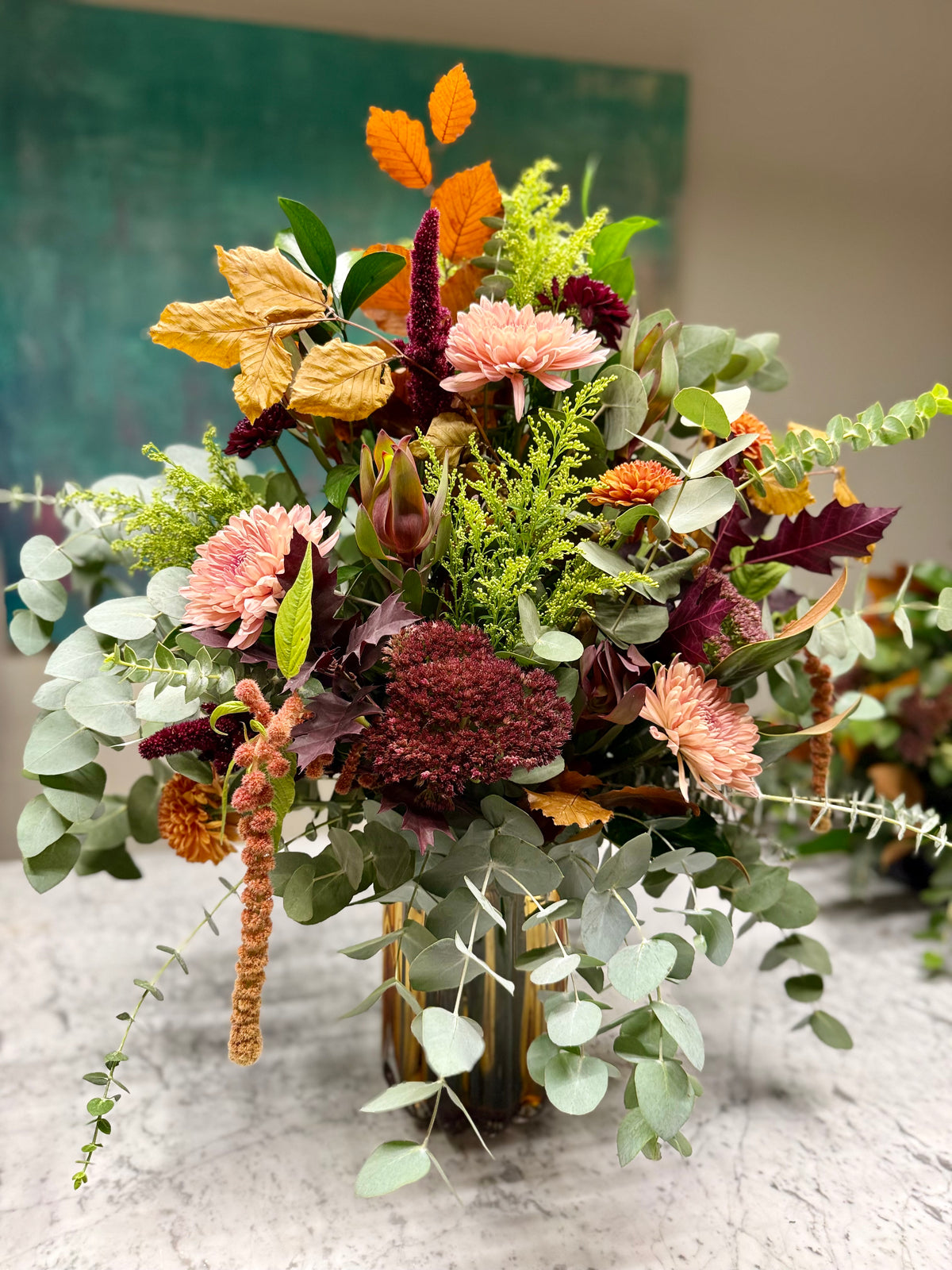 Arreglo floral en jarrón naranja en tonos de otoño