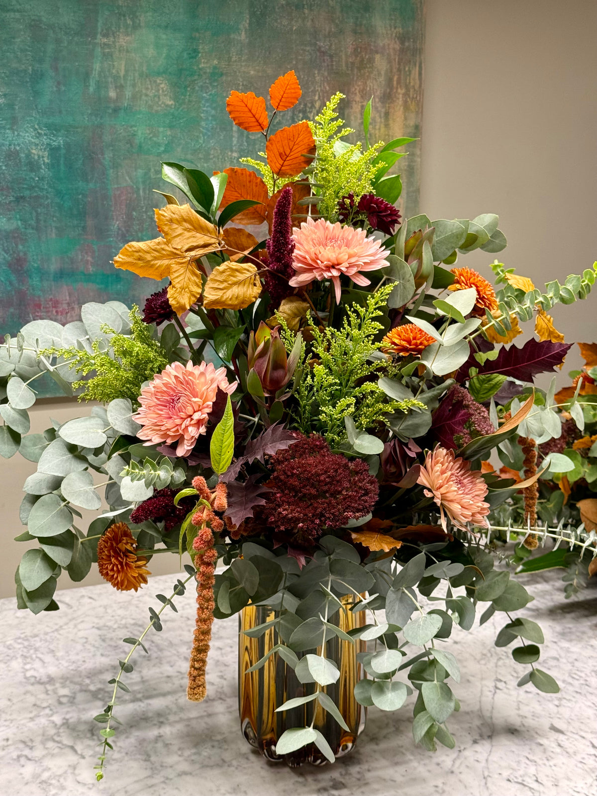 Arreglo floral en jarrón naranja en tonos de otoño