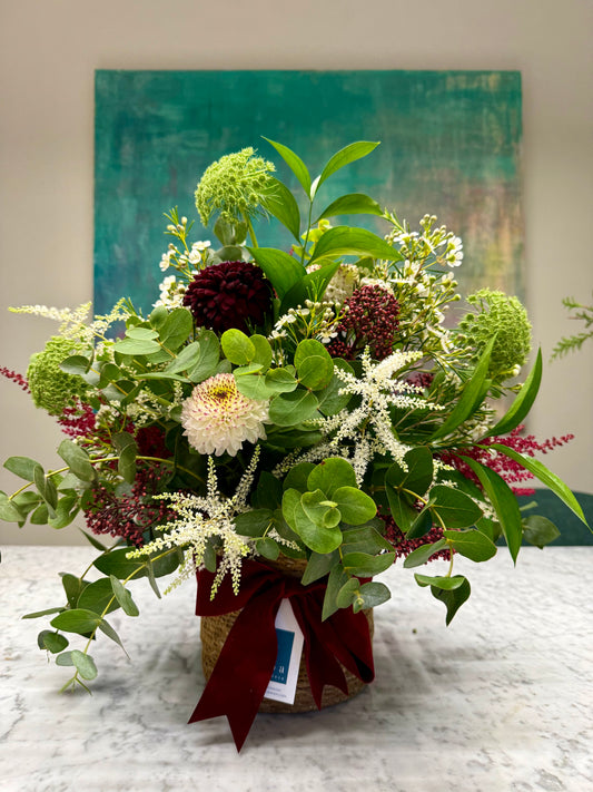 Arreglo floral en cesta en tonos burdeos y blancos