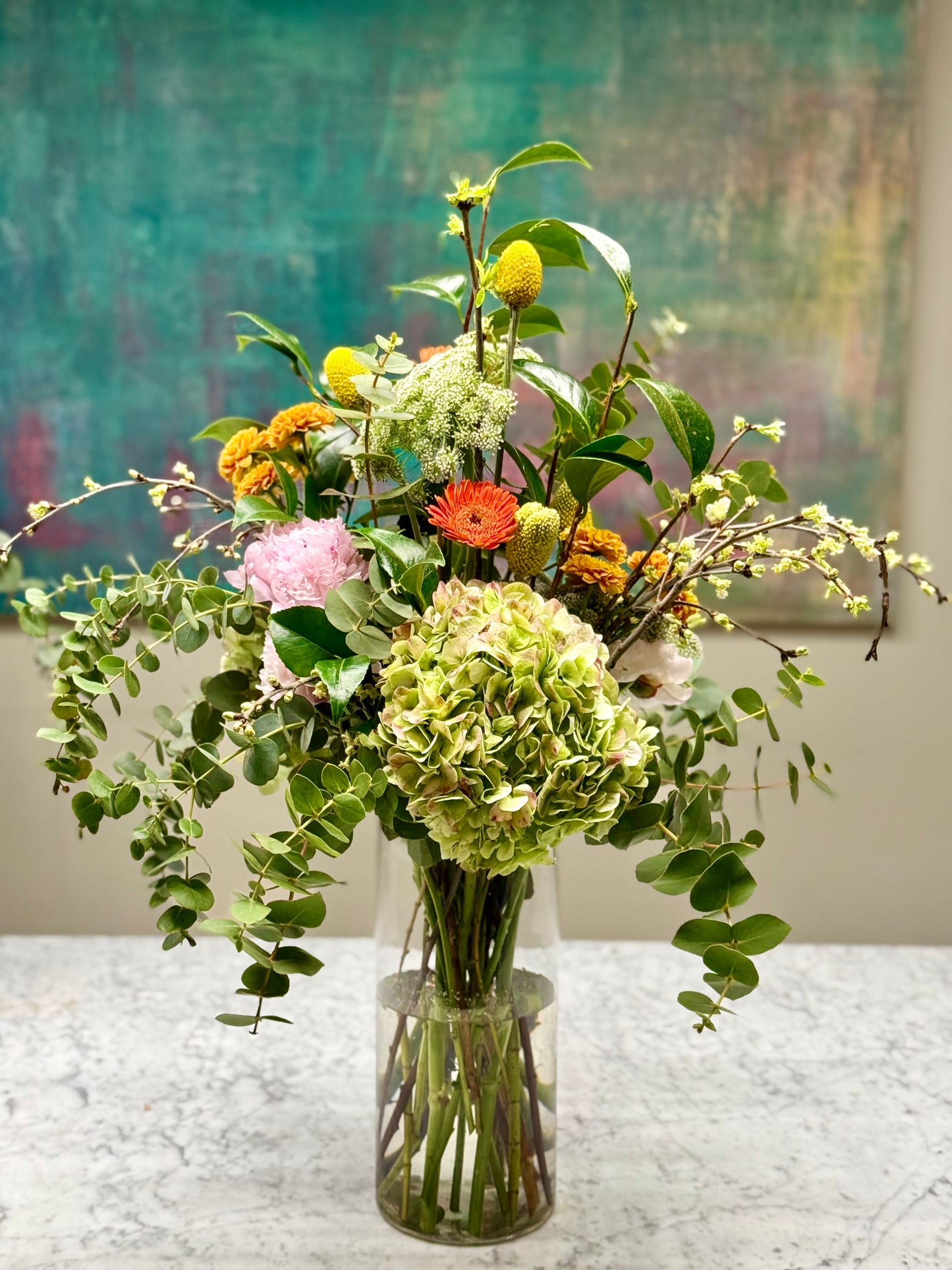 Arreglo Floral Tonos Verde, Amarillos y Naranjas con Hortensia