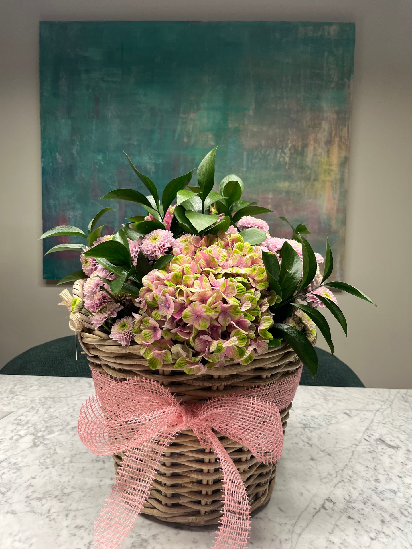 Arreglo floral de Hortensias en cesta y kit de bebé